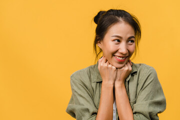 Portrait of young Asia lady with positive expression, smile broadly, dressed in casual clothing over yellow background. Happy adorable glad woman rejoices success. Facial expression concept.