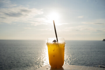 glass of orange juice on beach