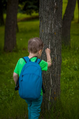 Portrait of a child, a boy against the background of plants in an open-air park. Children, Travel. Lifestyle in the city. Center, streets.