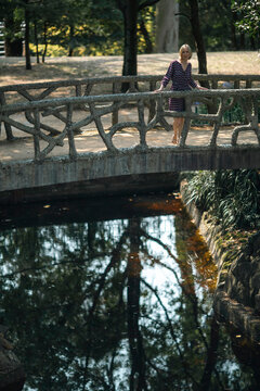 A woman standing on a bridge in an old park. Porto, Portugal.