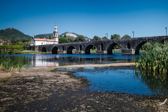 View of the long medieval bridge (ponte) that passes over the Lima river that runs next to the Ponte de Lima town, Portugal.