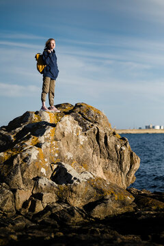 A woman tourist standing on the coastal ocean cliffs.