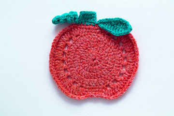 Orange green pumpkin shaped cup coaster on a white background. Crochet stand for hot. Kitchen tools and accessories. Halloween handmade concept. Copy space. Top view.
