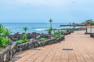Embankment in Jardines de Playa Chica park in Puerto de la Cruz, Spain. Beautiful landscape of the Atlantic Ocean promenade in the resort town of the Canary Islands