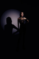 Hot sexual woman in latex suit on a dark background. Woman dominance concept