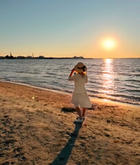 woman on white dress watching pink sunset on beach at sea romantic nature landscape seascape 