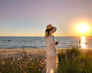 woman on white dress watching pink sunset on beach at sea romantic nature landscape seascape 