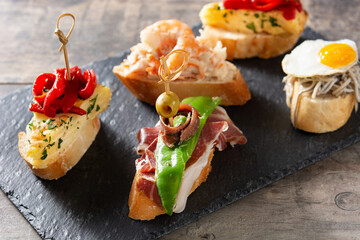 Assortment of Spanish pintxos on wooden table	