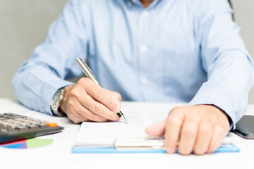 Fototapeta premium professional businessman hand holding pen writing and sign paperwork or document finance indoor at office, man manager person handwriting paper on clipboard and signature agreement approval business