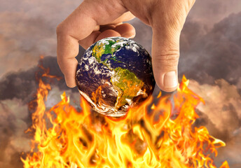 Human holding earth on fire, global warming concept