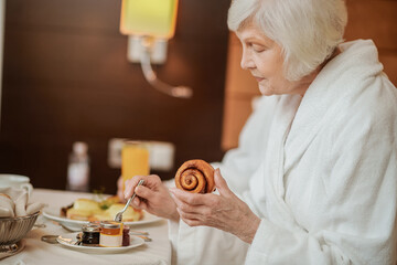 A woman in a white robe having breakfast