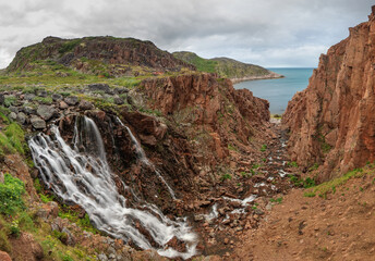 Panoram of the waterfall on the creek from Lake Small Batareyskoe, flowing into the Barents Sea through the canyon near the village of Teriberka