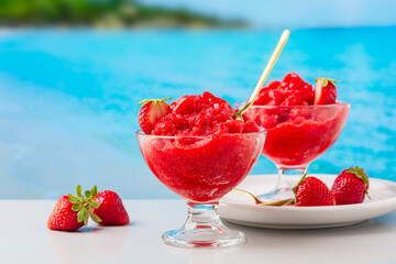 Italian summer sweet fruit food. Strawberry granita Siciliana, a semi-frozen dessert.  Sea view on...