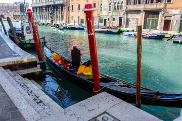 Venetian gondolier punting gondola on green canal waters of Venice Italy © Ap Ethical Design