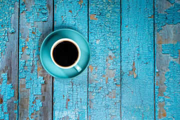 black coffee in a blue ceramic cup on the old blue wooden floor