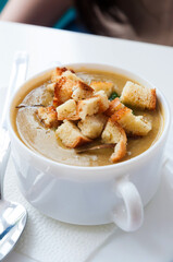 a bowl of mashed soup with croutons in a cafe