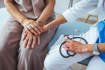 Hand of doctor reassuring her female patient. The doctor or pharmacist is discussing and...