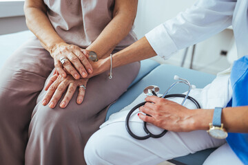 Friendly female doctor's hands holding female patient's hand for encouragement and empathy....
