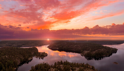 Summer Karelia. Russian landscape. Red sunset over Lake Ladoga. Nature of Russia. Beautiful pink sky over Karelia. Ladoga skerries and forests. Karelia tourism. Northern nature view from quadrocopter