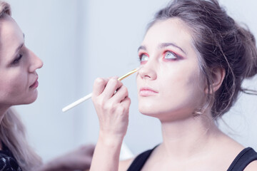 Obraz premium Makeup. Makeup artist applies corrective tonal tool. Close-up.