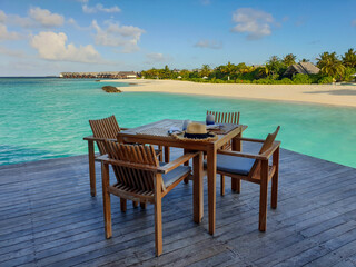 wooden table and chairs on the background of the sea