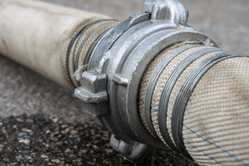 Fire service hose. Fire extinguishing equipment. Fabric hose with metal fitting. Fragment of hose...
