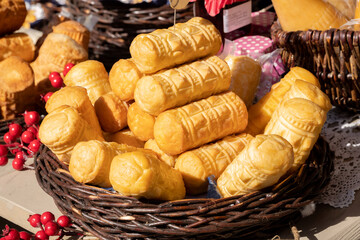Lots of fresh tasty Polish oscypki, pieces of oscypek smoked sheep cheese in a basket, group of objects, nobody, no people, closeup, detail. Traditional Polish food festival market, Polish culture