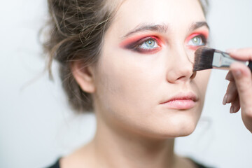 Makeup. Makeup artist applies corrective tonal tool. Close-up.