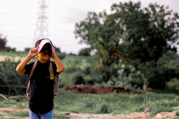 Young smiling happy male kid school boy 5-6 years old in shirt backpack look camera outdoor...