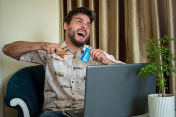 Hombre rompiendo su tarjeta de credito al ver sus gastos online