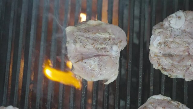 Chicken leg in barbeque grill fire, cheff turning with barbecue tongs