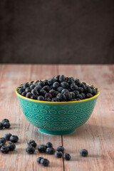 Fototapeta na wymiar Blueberries in a bowl on wooden table