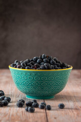 Blueberries in a bowl on wooden table
