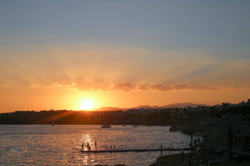 Sunset on the beach in Hurghada. Egyptian dessert in summer evening . African hills and sea horizon.