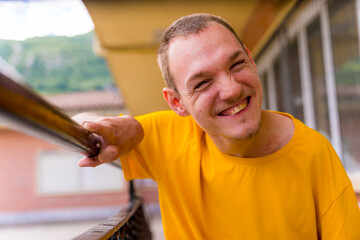 Portrait of a disabled person dressed in yellow in a wheelchair at school smiling