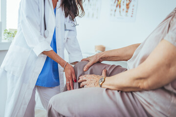 Doctor examining patient knee. Physiotherapist exam patient's knee. Senior patient with knee injury visit his physiotherapist. Doctor the traumatologist examines the patient the patient's ankle leg.. - obrazy, fototapety, plakaty