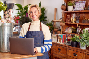 Portrait Of Female Owner Of Florists Shop Using Laptop
