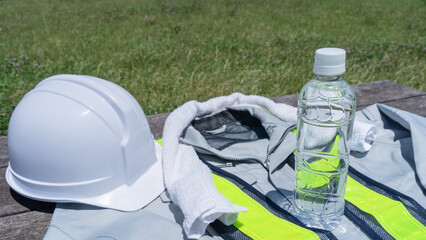 作業服とプラスチックボトルの水｜建設業の熱中症対策イメージ