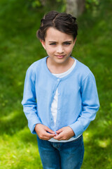 upset ukrainian child looking at camera outdoors