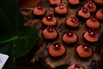 sweets decorated with flowers on party table, candy store, chocolate truffles, brigadeiro, chocolate sprinkles, chocolate candy