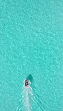 Vertical shot of a boat in the turquoise water