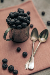 concept of healthy breakfast by cup full of blueberries with vitamins
