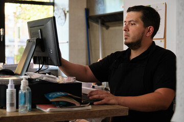 Latin waiter at the cash desk. Restaurant.