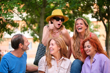 Portrait of five mature adults having in a park.
