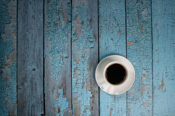 black coffee in white ceramic cup on the old blue wooden floor