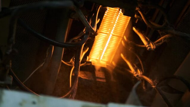 fiberglass furnace. red-hot threads move through a hot furnace. fiberglass production. heat