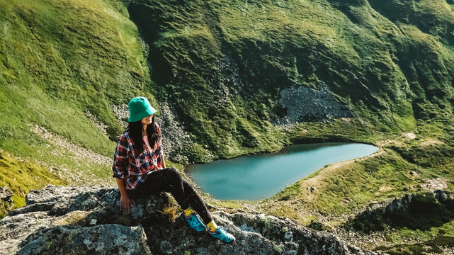 Woman tourist on background of green mountains and lake