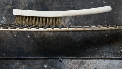 Close-up view of the cleaning brush on the oven steel rack