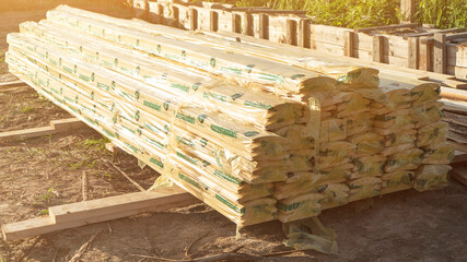Stack of wooden boards packaged in film at construction site