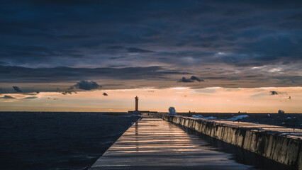 Obraz premium Scenic landscape of sunset over Baltic sea. Cloudy sky. Mangalsala mols. Way to lighthouse. Dramatic seascape.